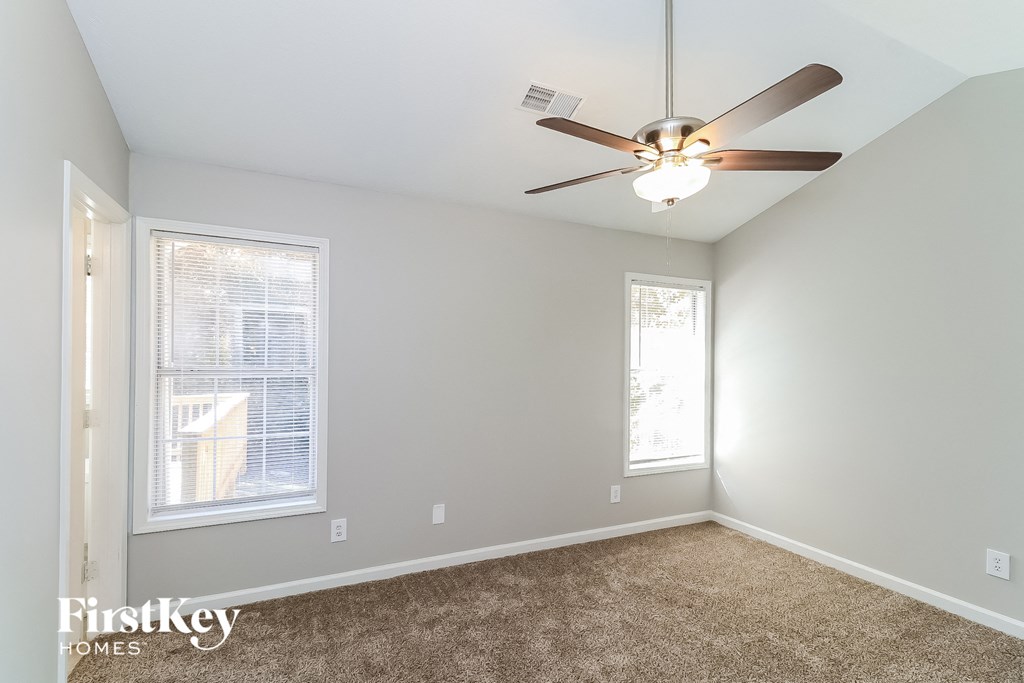 a bedroom with a ceiling fan and a window