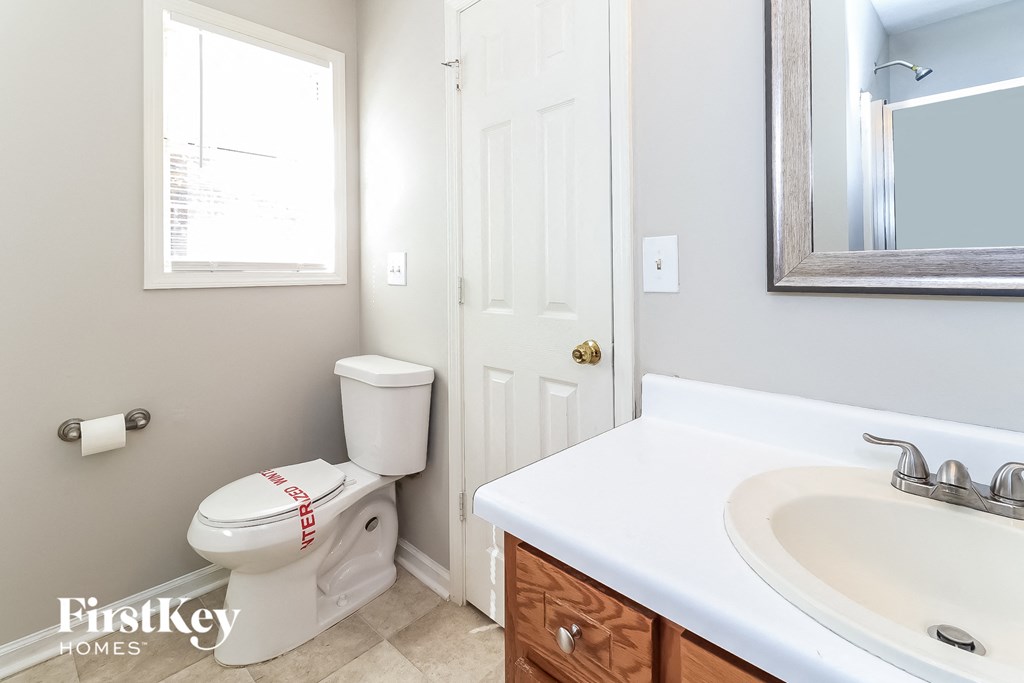 a bathroom with a sink toilet and a mirror