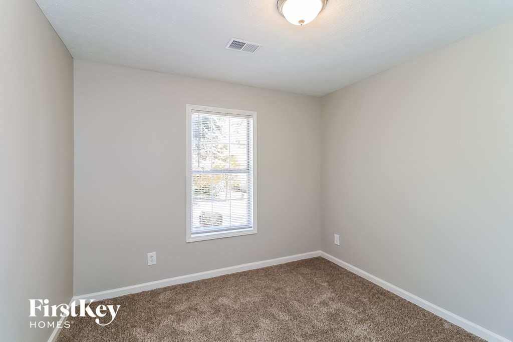 an empty room with carpet and a window
