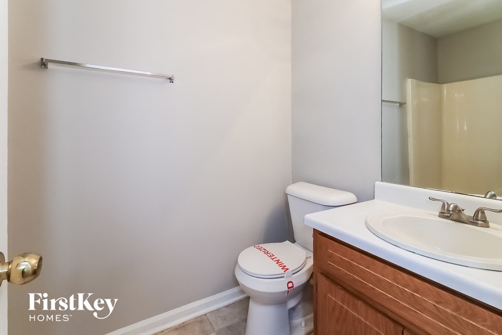 a bathroom with a sink toilet and a mirror