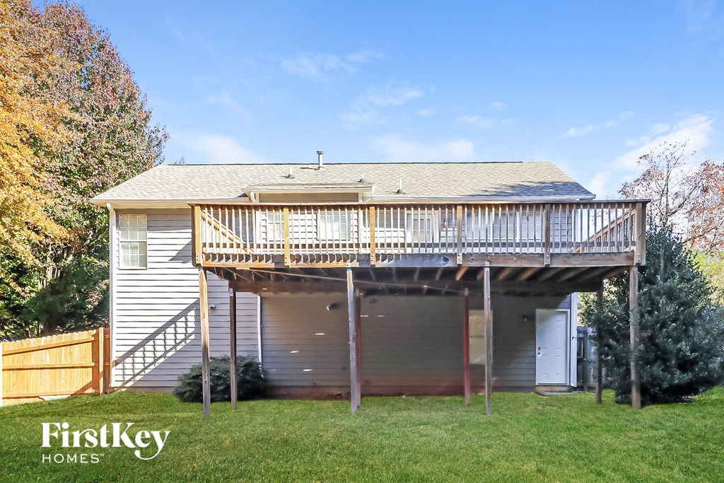 the back of a house with a deck on top of it