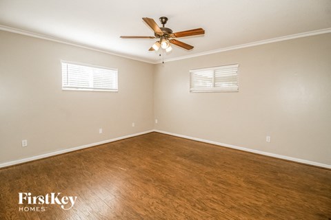 a bedroom with a ceiling fan and a wood floor