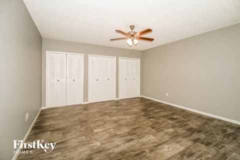 a living room with a ceiling fan and a closet