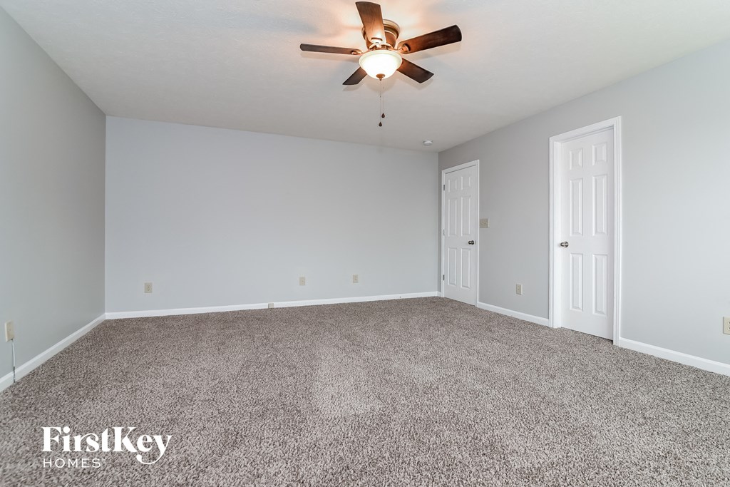 A room with a ceiling fan and two doors.