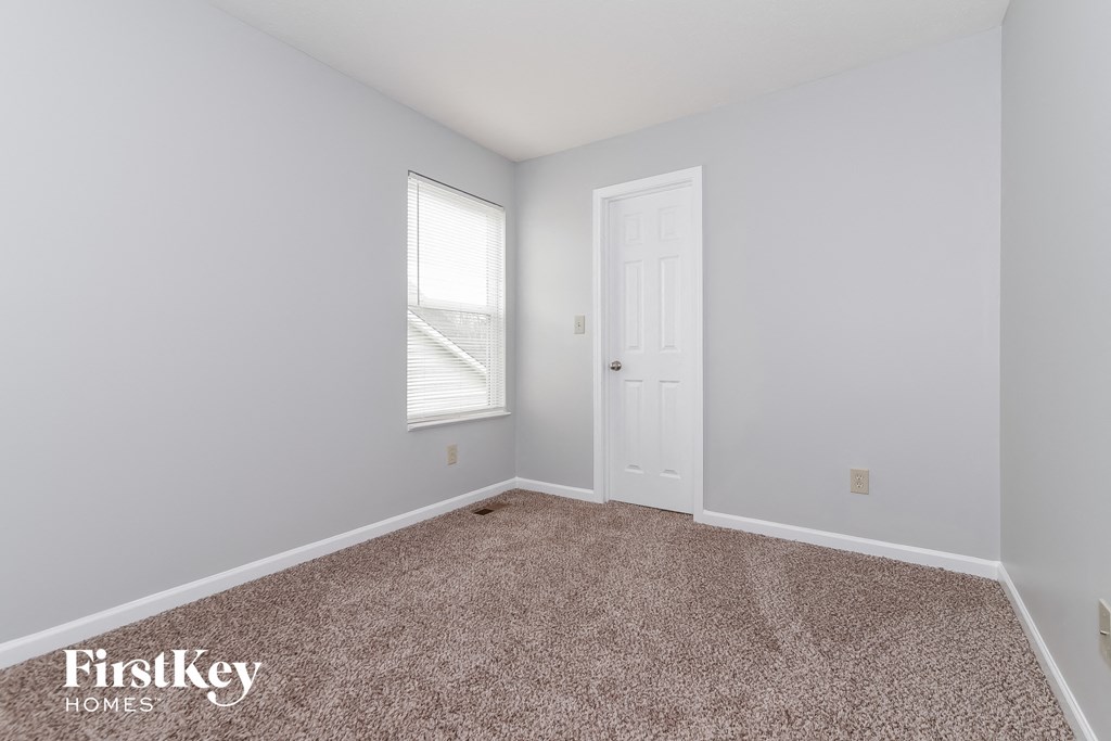 A room with a carpeted floor and a door.