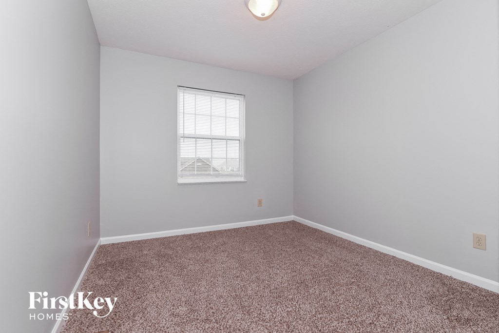 A room with a carpeted floor and a window.