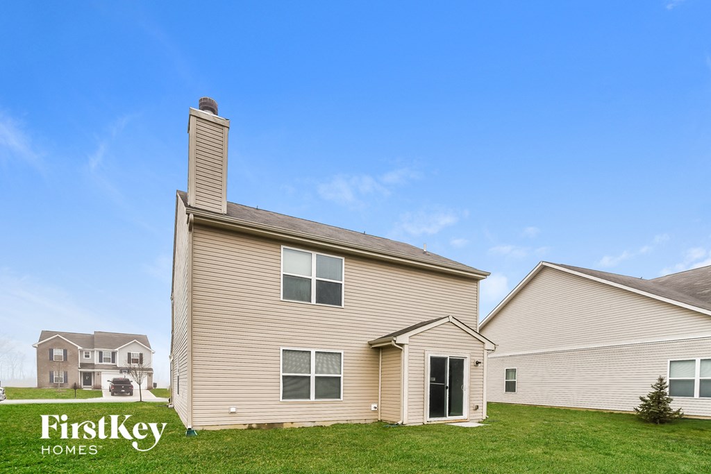 A house with a chimney and a sign that says "FirstKey Homes" in front of it.
