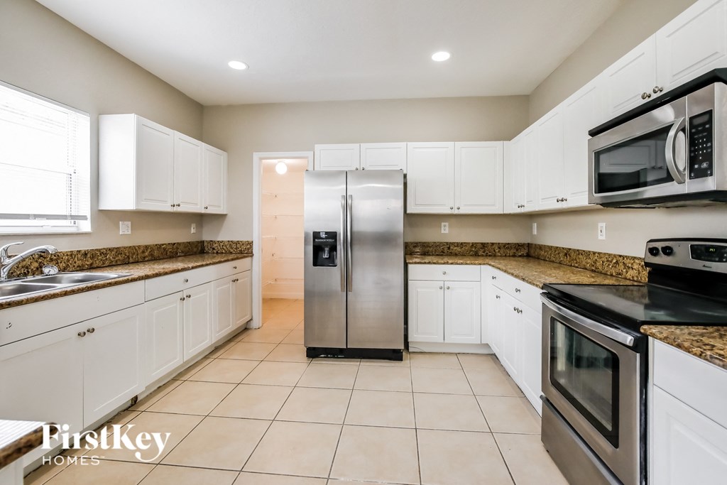 a kitchen with white cabinets and stainless steel appliances