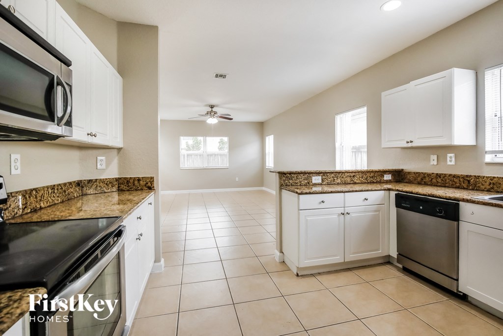 a kitchen with white cabinets and granite counter tops