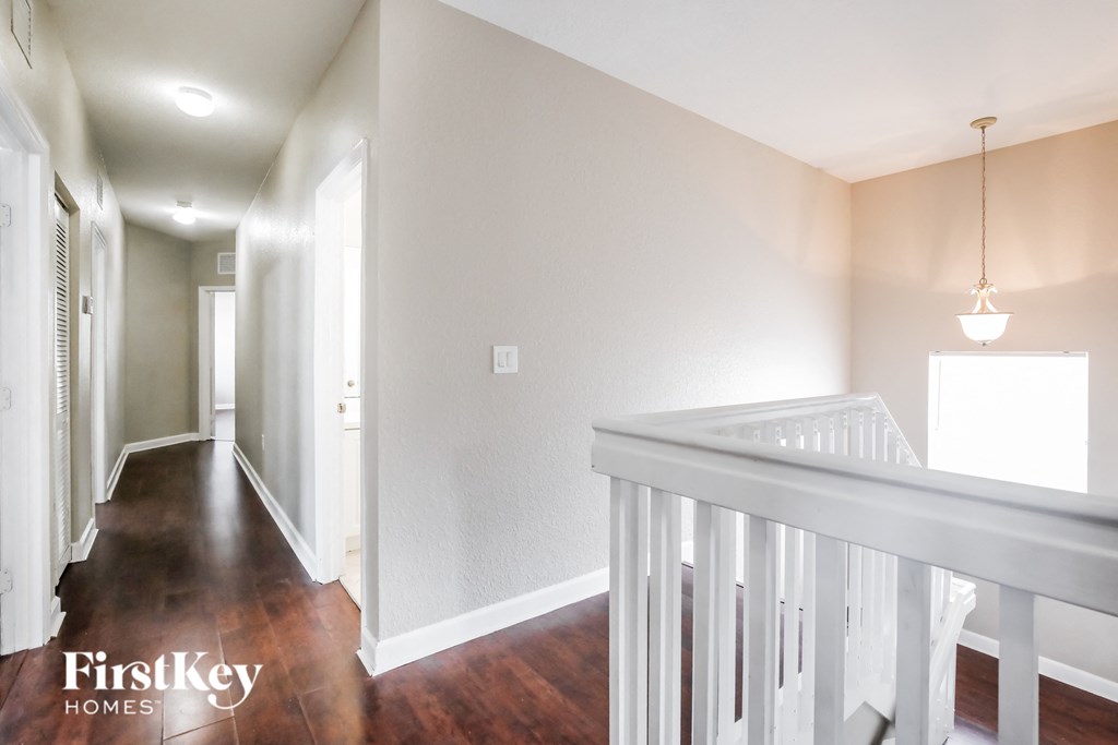 a hallway with a white staircase and a hallway in a house