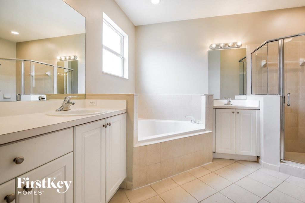 a bathroom with a tub and a sink and a mirror