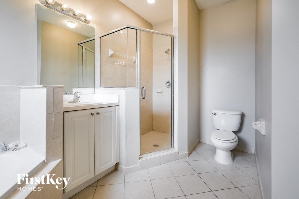 a white bathroom with a shower toilet and sink