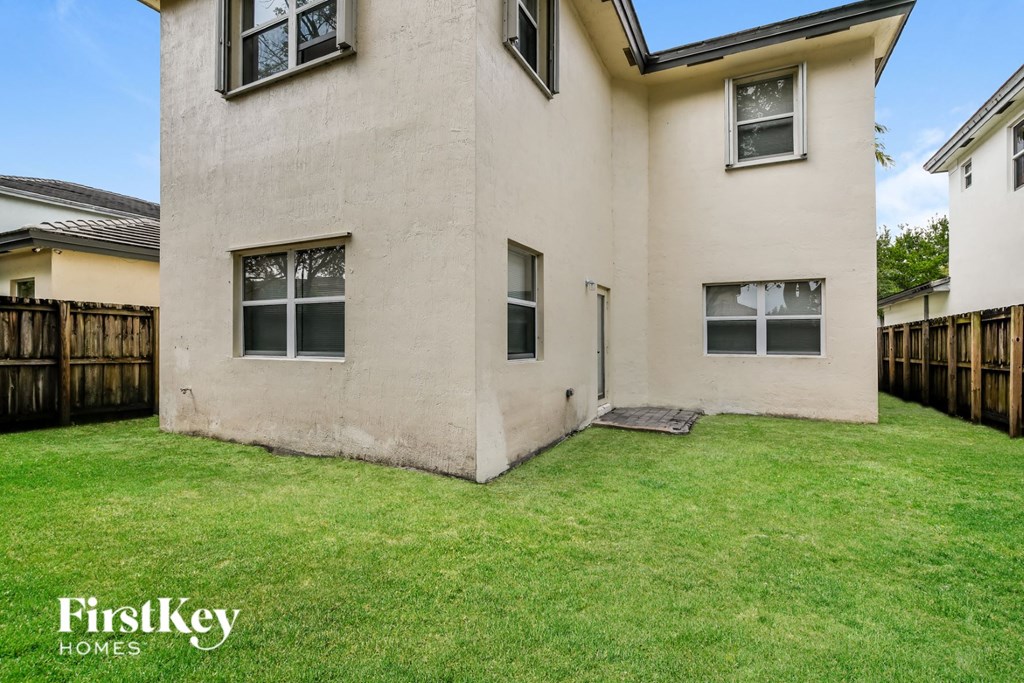 a white house with a yard and a wooden fence