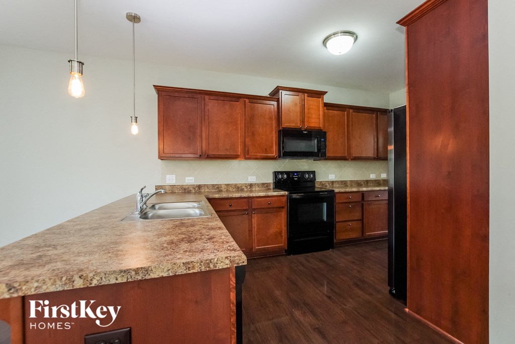 a kitchen with wooden cabinets and granite counter tops and a sink