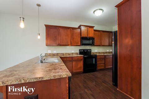 a kitchen with wooden cabinets and granite counter tops and a sink