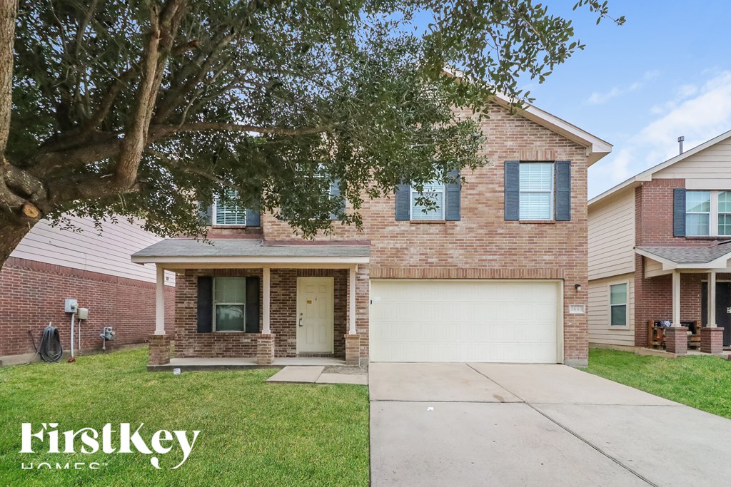 A brick house with a garage door is for sale.