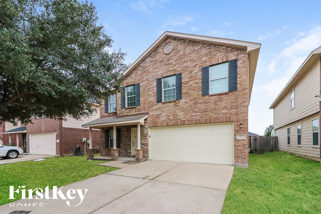 A brick house with a garage is for sale.