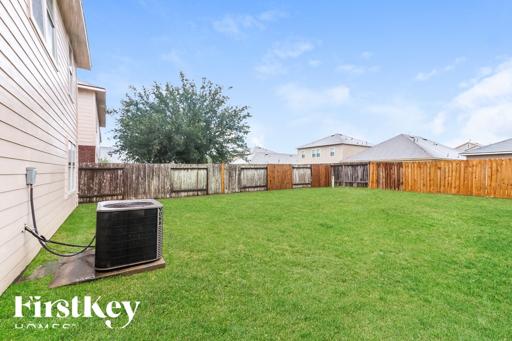A backyard with a lawn and a fence.