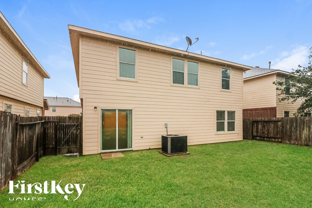 A house with a brown siding and a green lawn.