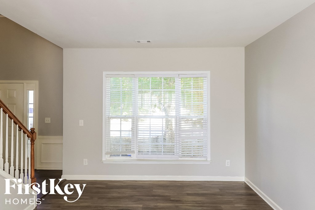a living room with a large window with white blinds