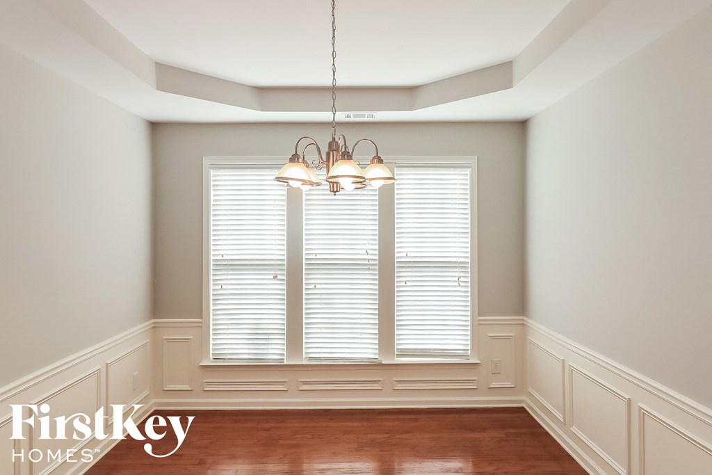 a dining room with two windows and a chandelier