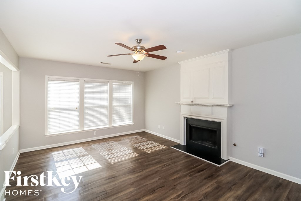 a living room with a fireplace and a ceiling fan