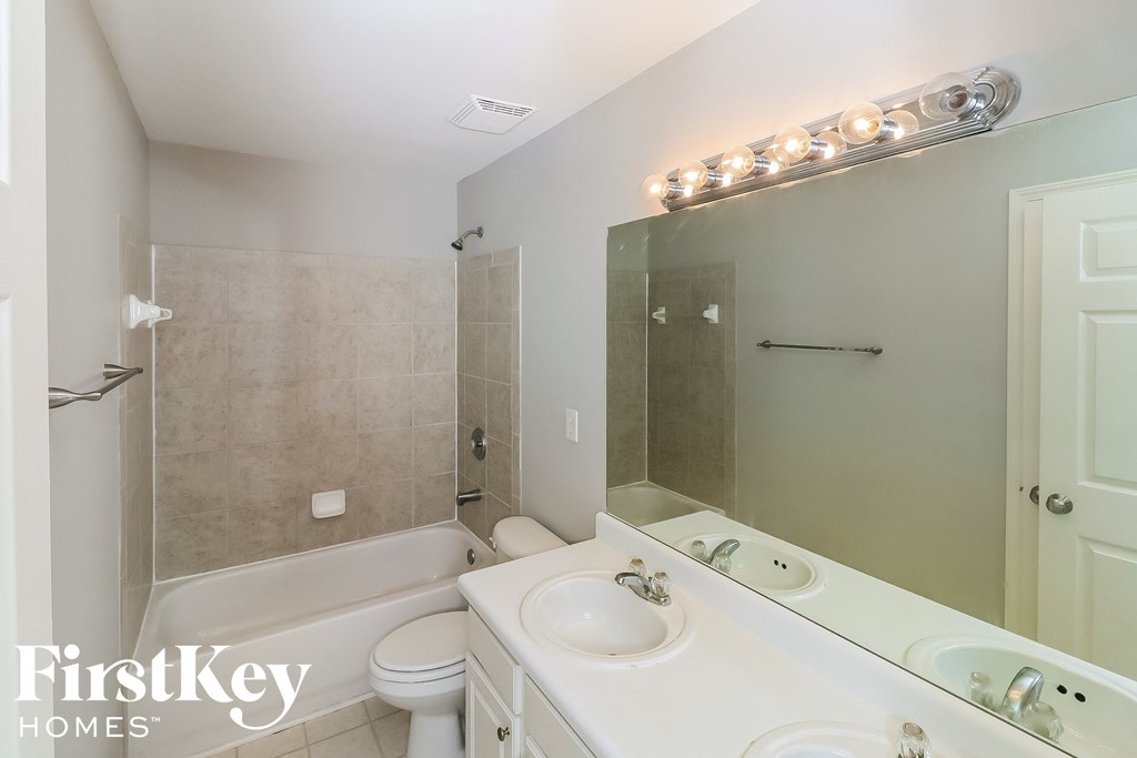 a white bathroom with a white sink and a shower and a toilet