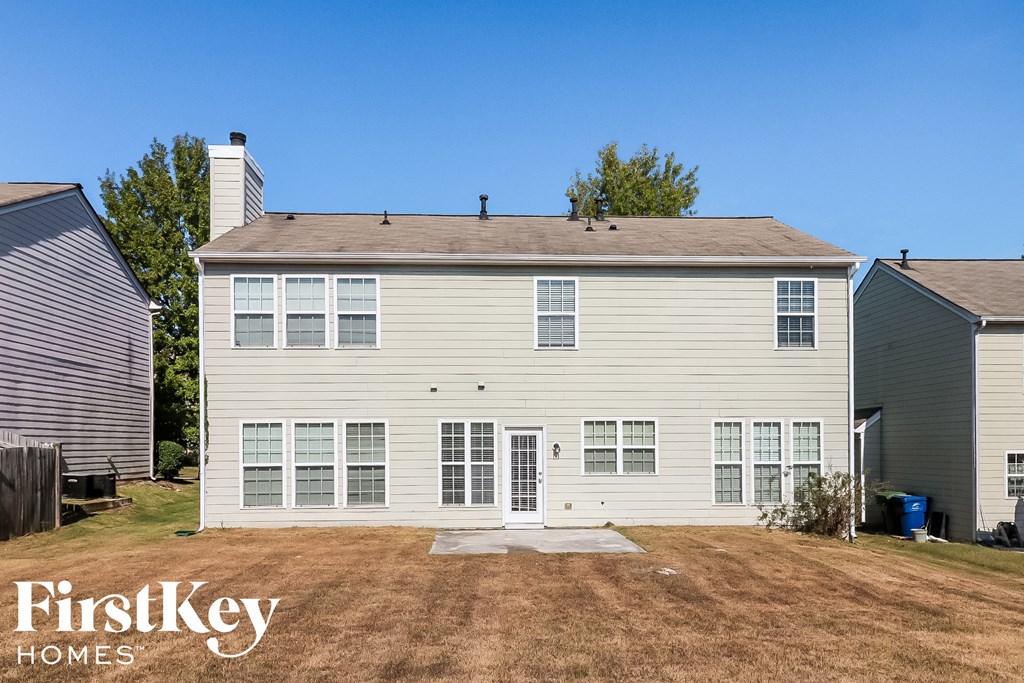 side view of a white house with a yard and a garage