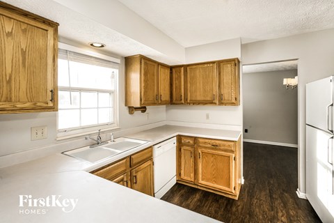 A kitchen with wooden cabinets and a white sink.
