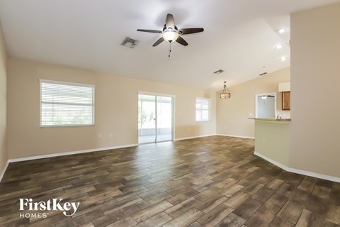 A spacious room with wooden flooring and a ceiling fan.