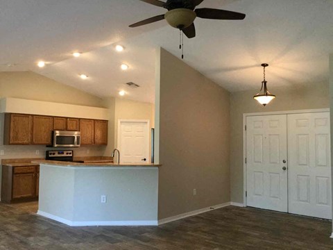 A kitchen with a white counter and brown cabinets.