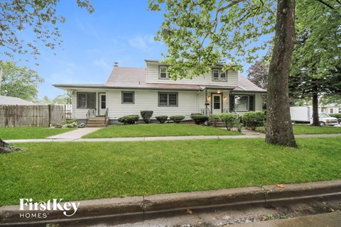 a white house with a yard and a tree