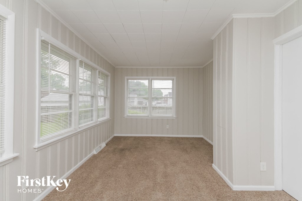 a bedroom with a carpeted floor and large windows