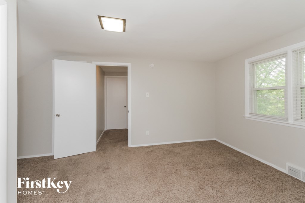 a bedroom with a carpeted floor and a door to a closet