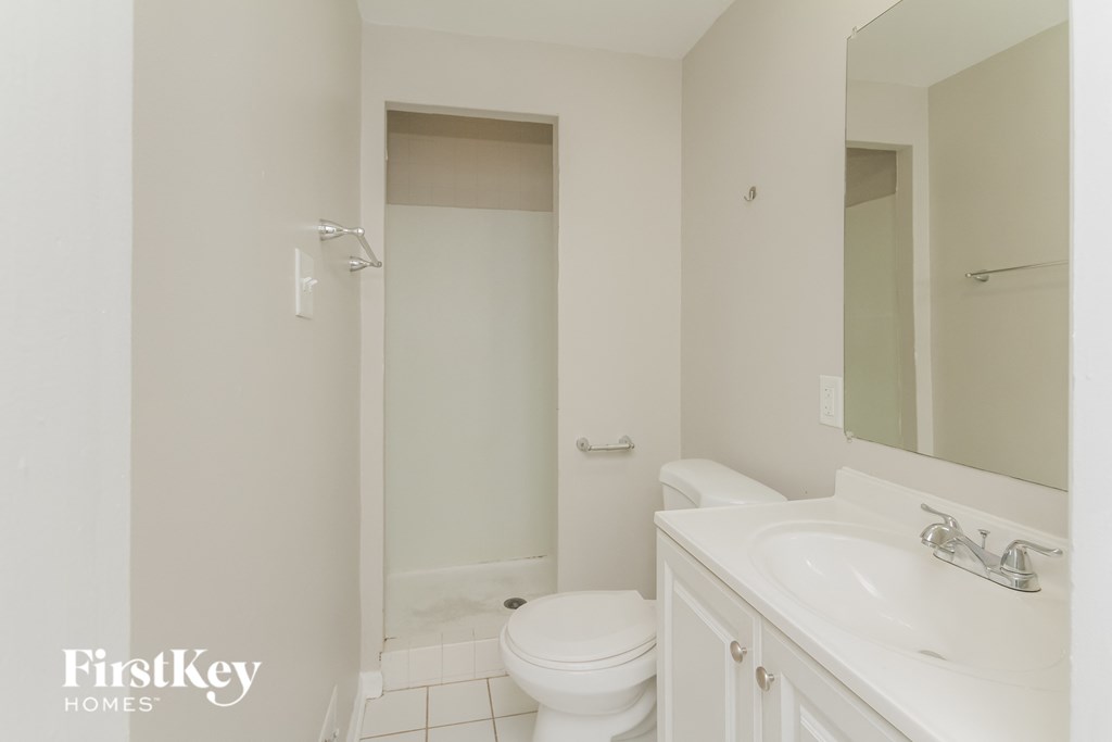 a white bathroom with a toilet and a sink