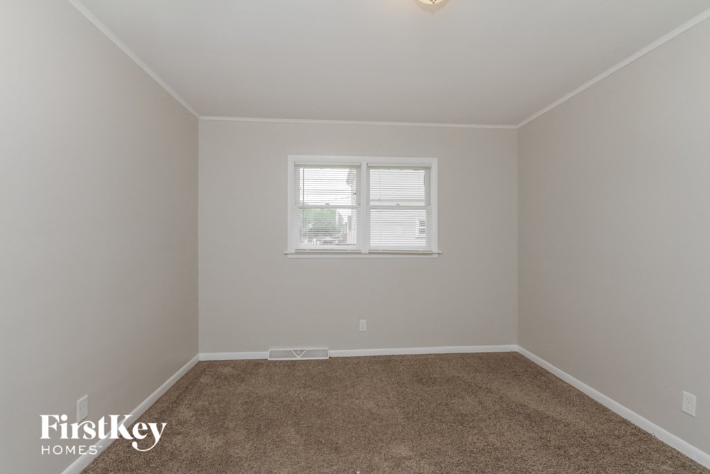 a empty room with carpet and a window