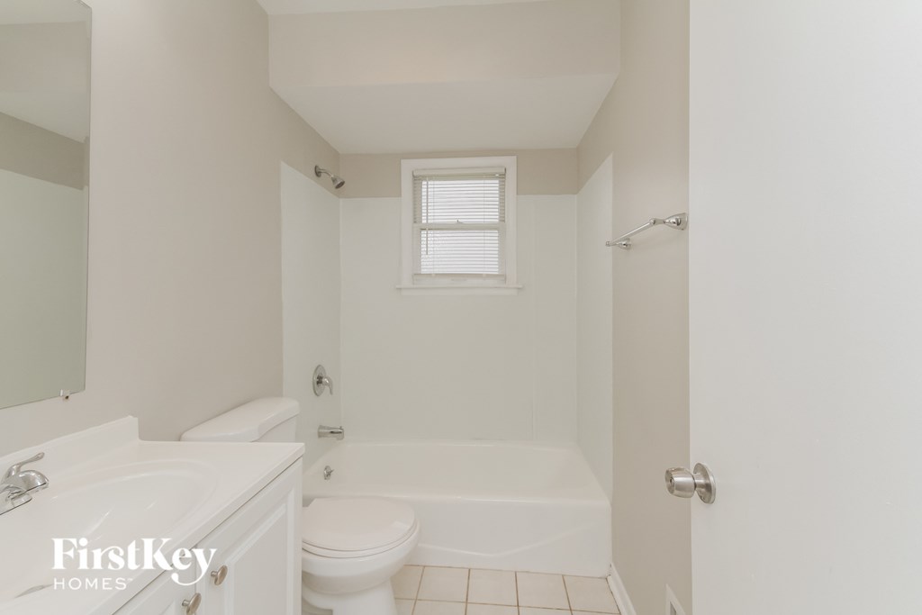 a bathroom with a toilet and a tub and a sink