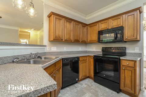 A kitchen with wooden cabinets and black appliances.