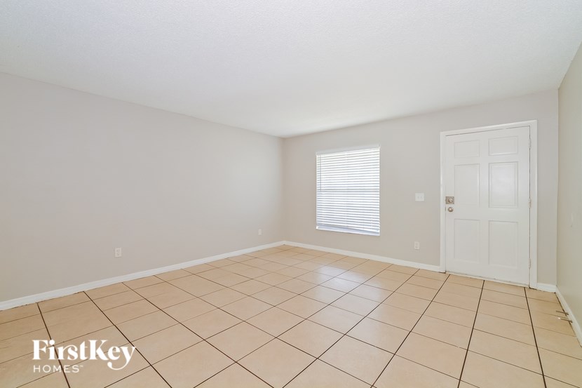A room with a white door and a window with blinds.