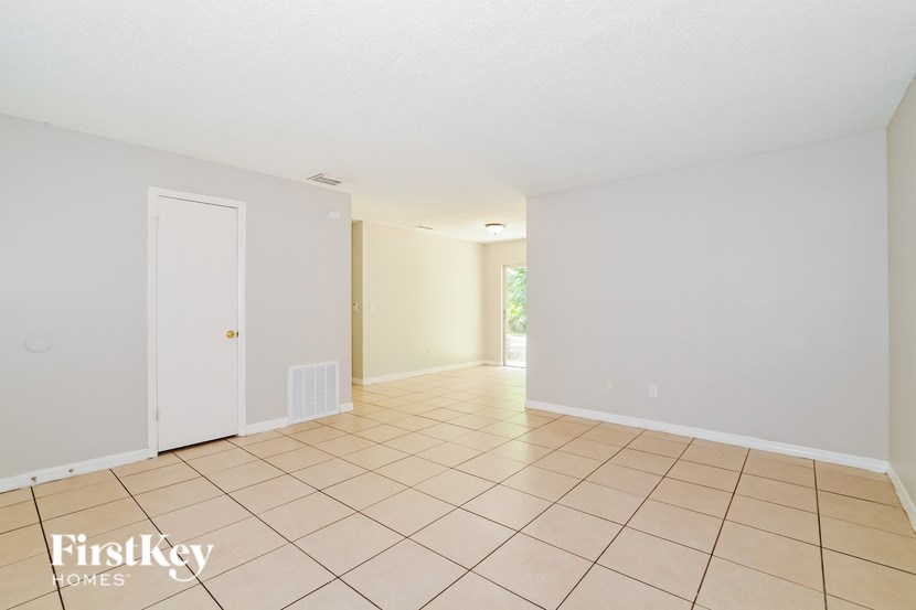 A room with a white door and a tiled floor.