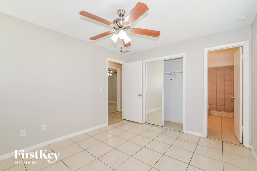 A room with a ceiling fan and tile flooring.