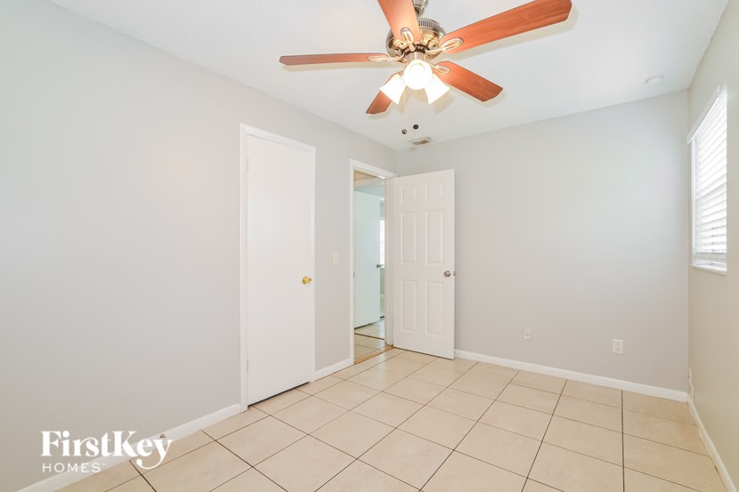 A room with a ceiling fan and a doorway leading to another room.
