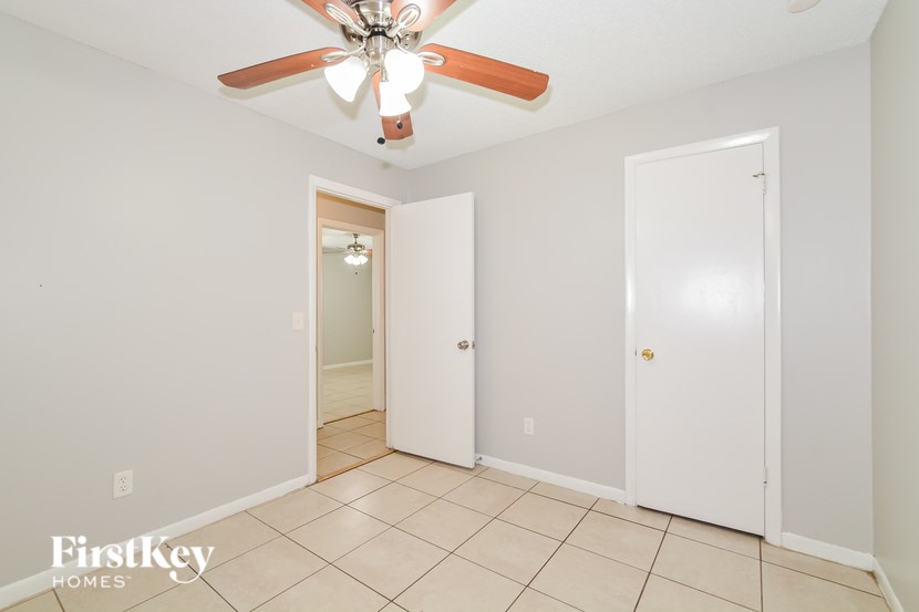 A room with a ceiling fan and two doors.
