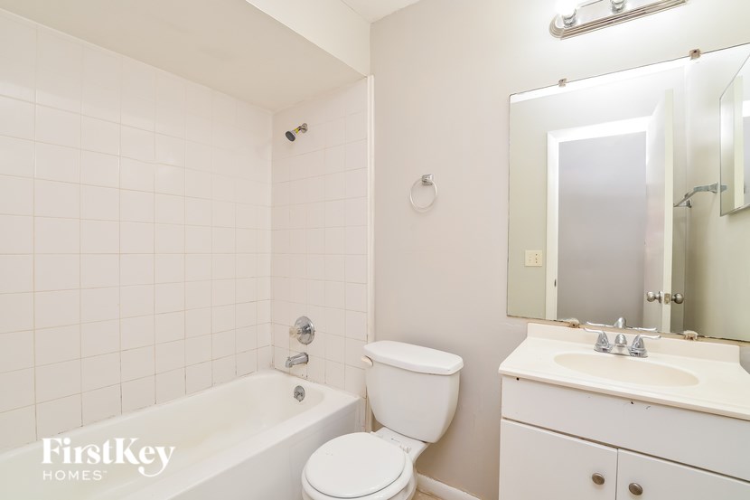 A white bathroom with a toilet, sink, and tub.