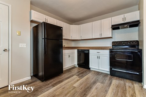 a kitchen with black appliances and white cabinets