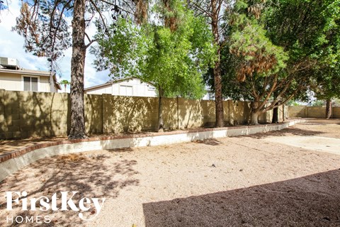 a backyard with a retaining wall and trees