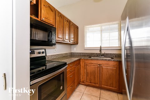 A kitchen with wooden cabinets and a stainless steel refrigerator.