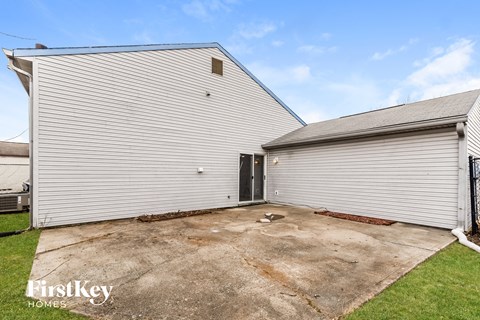 A large white garage with a roll-up door is situated in a grassy area.