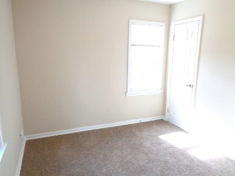 an empty room with a door and a window