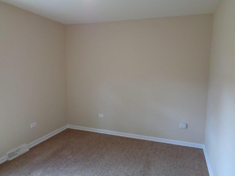 an empty room with beige walls and a carpet